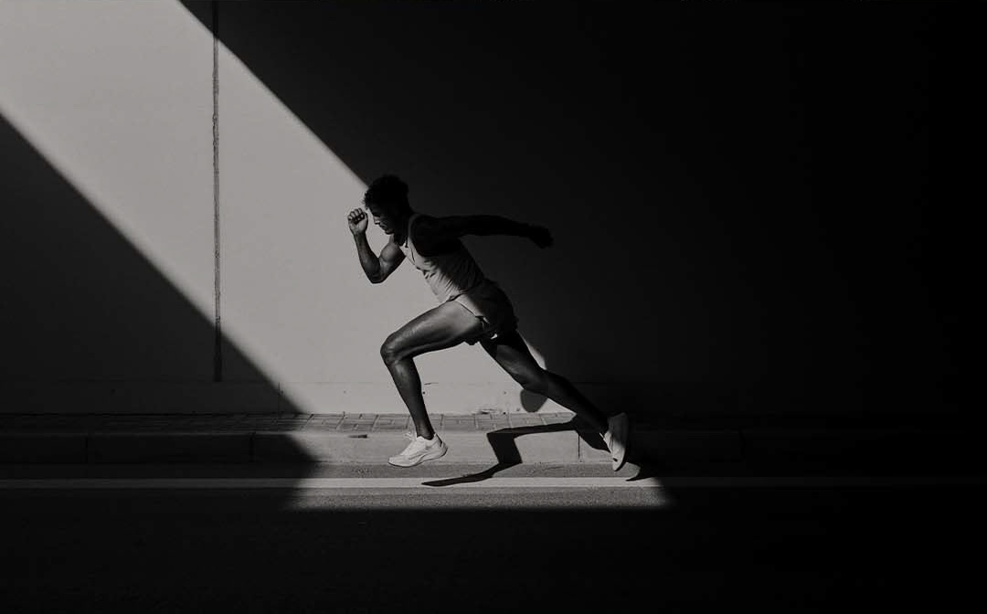 Runner moving through dramatic light and shadow
